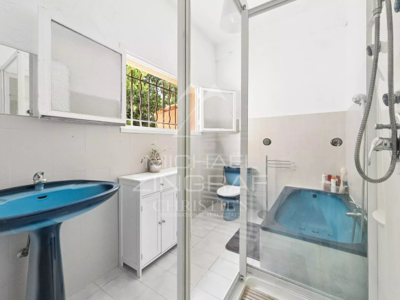 Bathroom with shower and bathtub, light tiles and modern features.