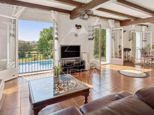 Interior of a villa in Mandelieu-la-Napoule with a bright living room and a view of the swimming pool.