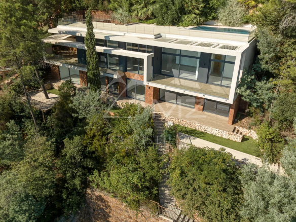 New contemporary villa in Théoule-sur-Mer, integrated into a green landscape, with swimming pool and terraces.