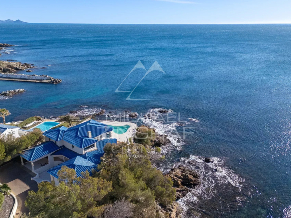 Vue aérienne d'une villa pieds dans l'eau aux Issambres, avec piscine et accès direct à la mer.