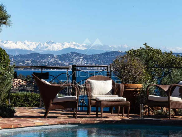 Vue depuis une villa à Théoule-sur-Mer avec piscine et montagnes en arrière-plan.