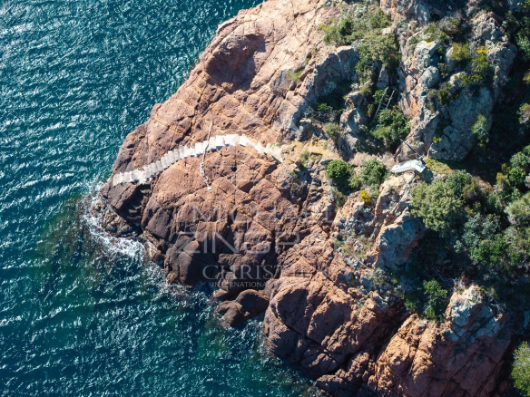 Vue aérienne des rochers et de la mer à Théoule-sur-Mer, avec un accès direct à l'eau.