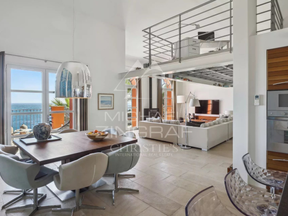 Intérieur d'une villa moderne à Théoule-sur-Mer avec vue sur la mer, salle à manger et salon lumineux.