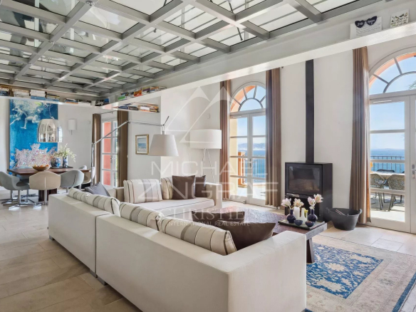 Intérieur d'une villa moderne à Théoule-sur-Mer avec vue sur la mer, salon lumineux et décor élégant.