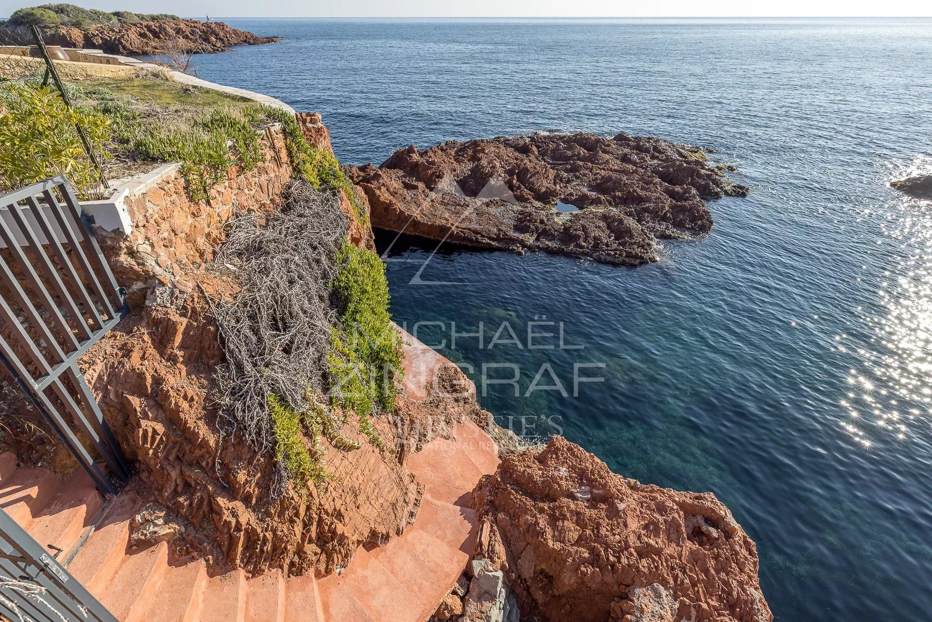 Accès à la mer depuis une villa en bord de mer à Saint-Raphaël, avec des rochers et des escaliers.