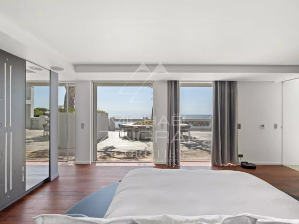 Chambre moderne avec vue sur la mer et accès à une terrasse.