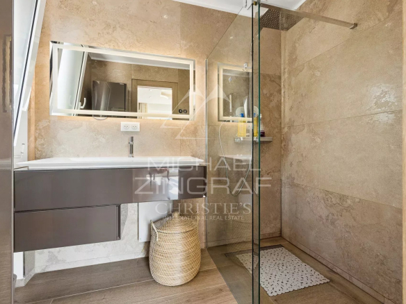 Modern bathroom with walk-in shower and vanity unit.
