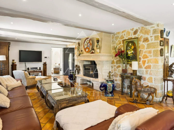 Spacious living room with fireplace and warm decor in a property in Mandelieu-la-Napoule.