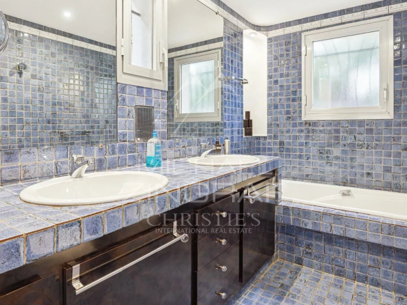 Bathroom with blue tiles, double sink and bathtub