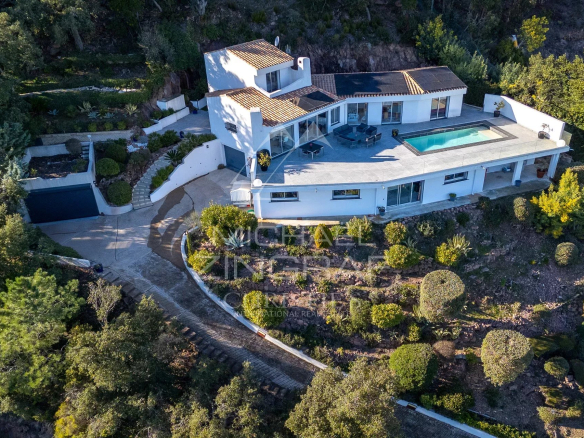 Modern house with swimming pool in a private estate in Mandelieu-la-Napoule, surrounded by greenery.