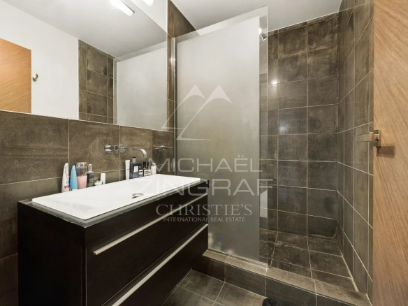 Salle de bains moderne avec douche et meuble vasque en bois.