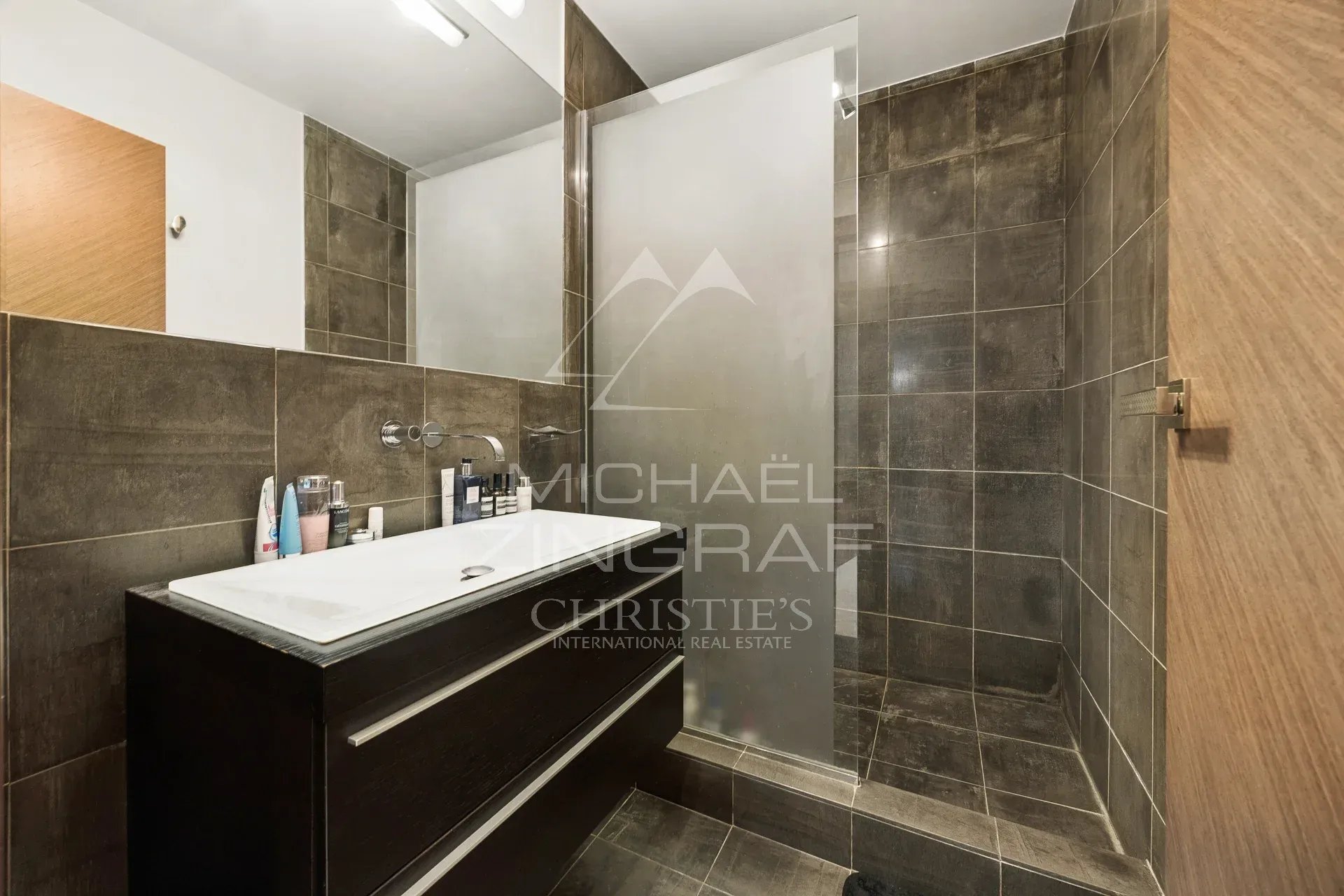 Salle de bains d’un appartement en duplex Salle de bains moderne avec douche et meuble vasque en bois.