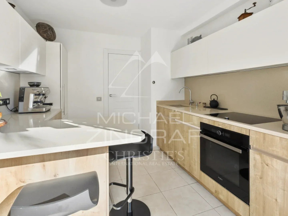 Cuisine moderne d'un appartement en duplex avec des meubles clairs et des équipements intégrés.