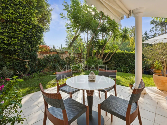 Terrasse avec table et chaises dans un jardin privatif verdoyant à Mandelieu-la-Napoule.