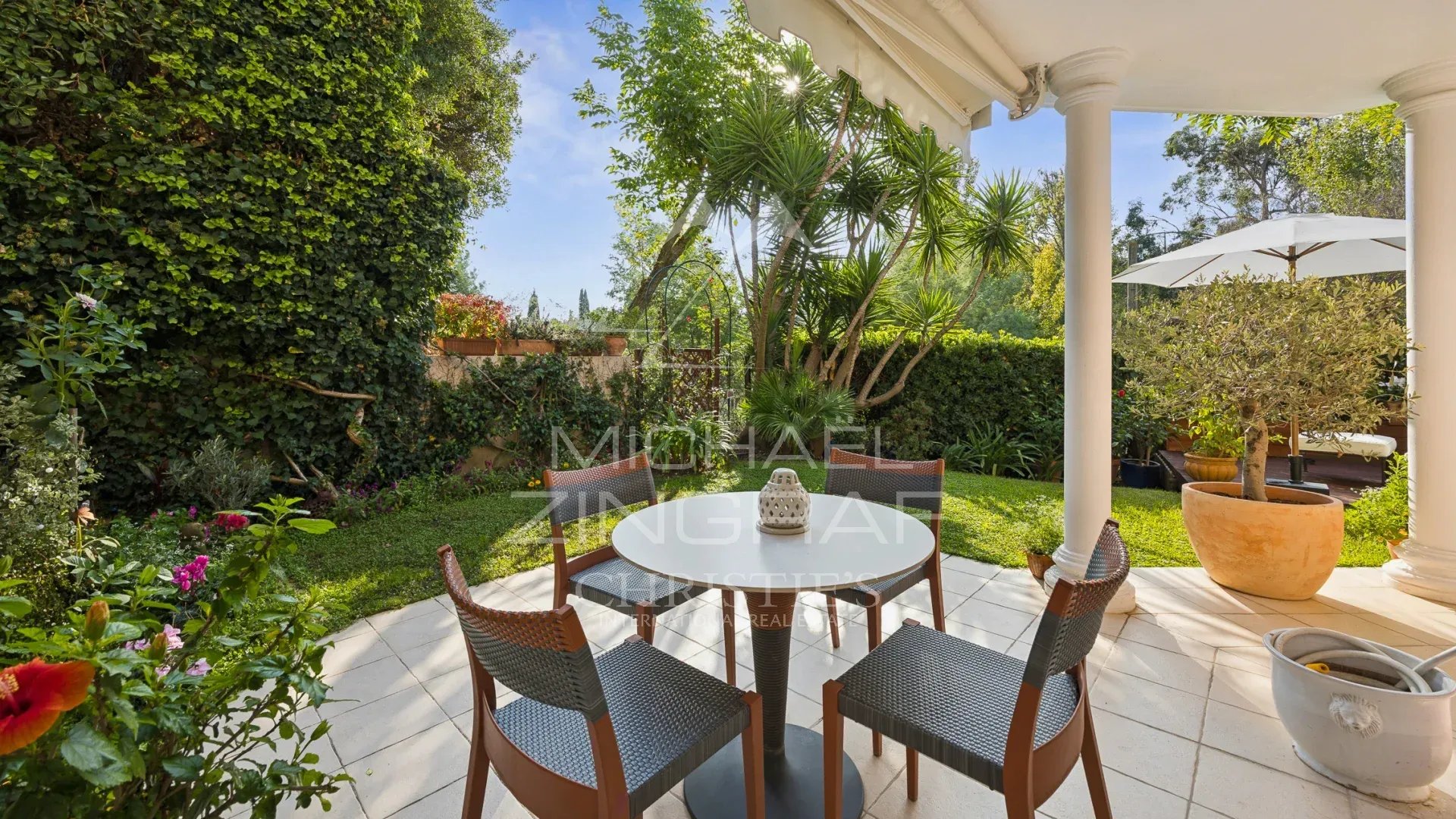 Jardin privatif d’un duplex à Mandelieu-la-Napoule Terrasse avec table et chaises dans un jardin privatif verdoyant à Mandelieu-la-Napoule.