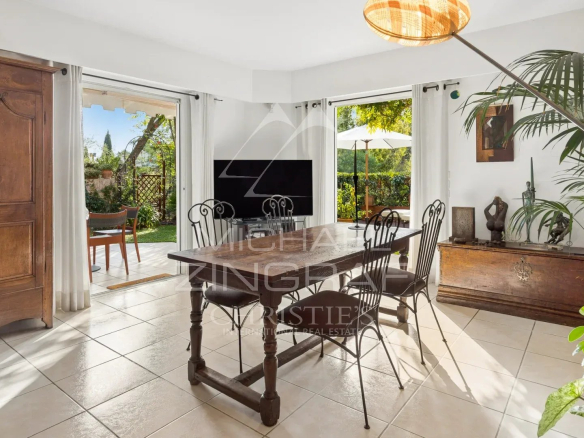 Intérieur d'un duplex lumineux avec salle à manger et accès au jardin privatif.