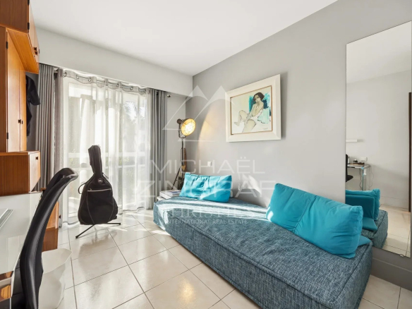 Intérieur d'un appartement en duplex avec un canapé et une grande fenêtre.