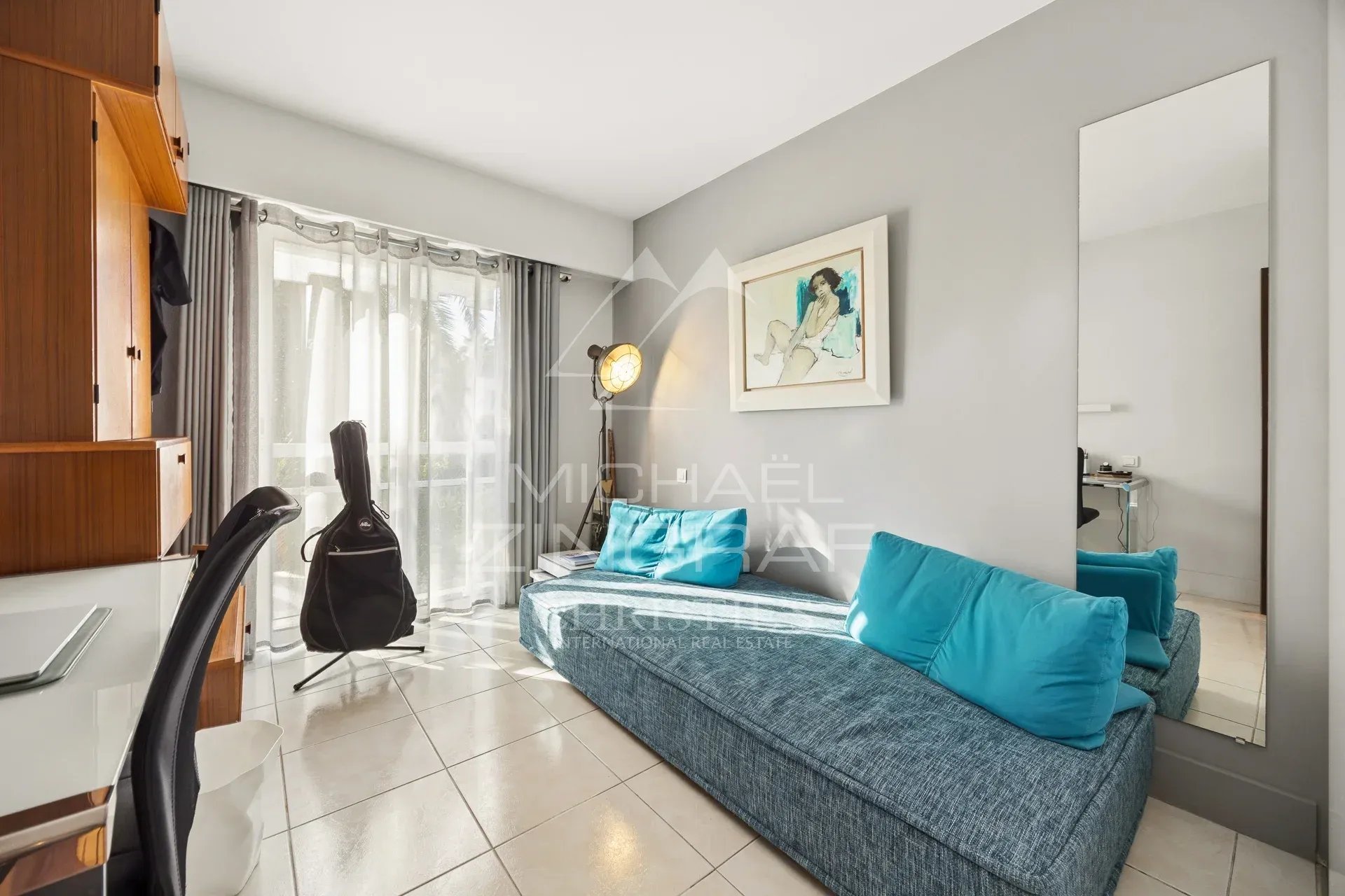 Appartement en duplex à Mandelieu-la-Napoule Intérieur d'un appartement en duplex avec un canapé et une grande fenêtre.