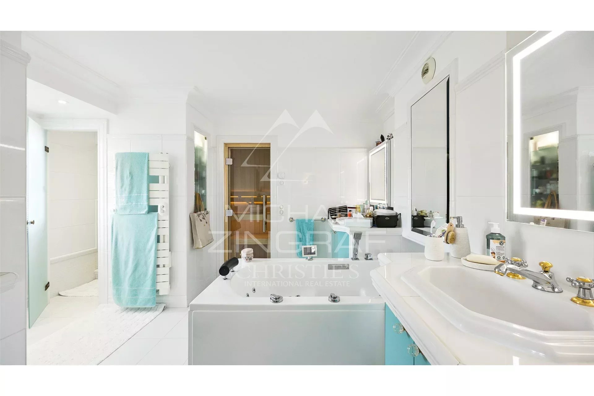 Salle de bain d’un appartement rénové Salle de bain moderne avec baignoire et lavabo, décorée en blanc et bleu.