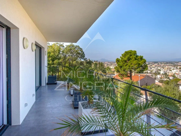 Vue depuis un balcon d'une propriété contemporaine à Saint-Raphaël, avec paysage urbain en arrière-plan.
