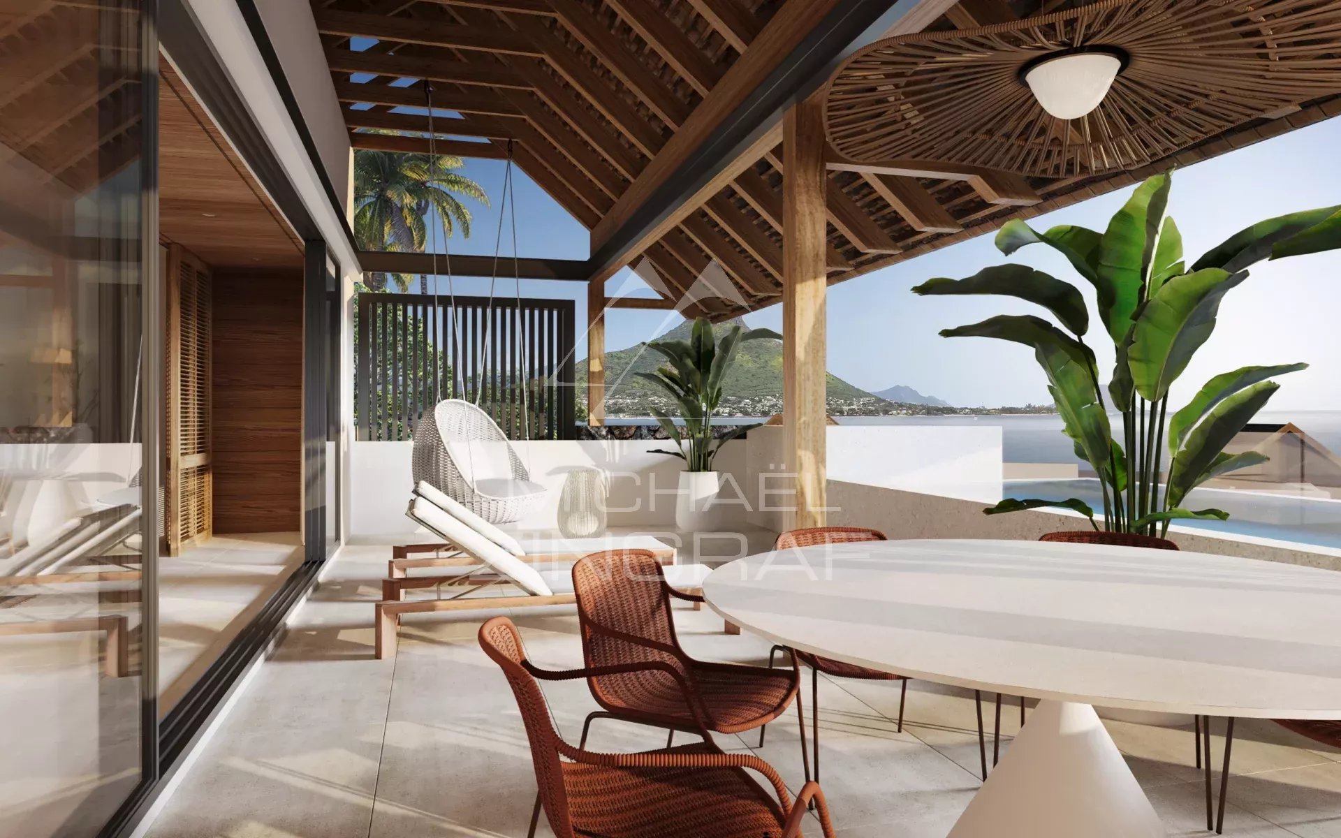 Terrace with white round table and wicker chairs, hanging lounge chair, wooden pergola, and tropical plants overlooking the sea and mountains in the distance.