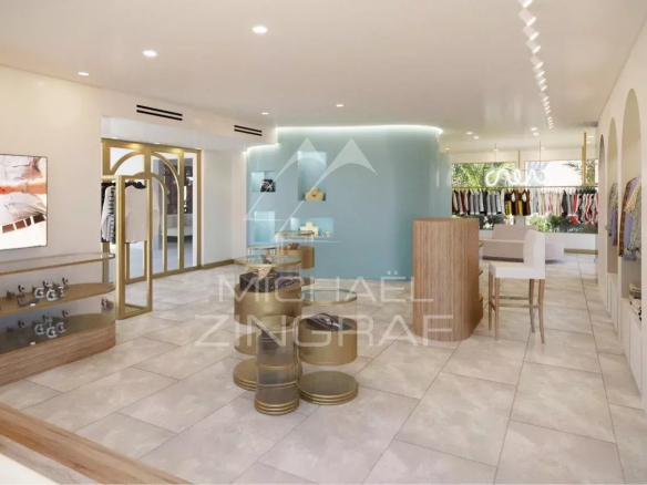 Boutique clothing store interior with white shelves, gold fixtures, and a teal curved wall featuring display shelves and seating area in the center