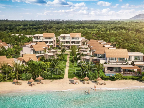 Luxurious beachfront resort with villa-style buildings among palm trees along a sandy shore and turquoise sea far from a forested hinterland, sunny sky.