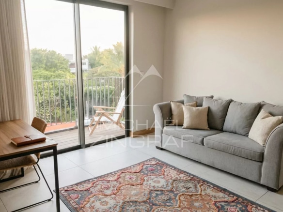 Intérieur d'un penthouse avec canapé et tapis, vue sur balcon.