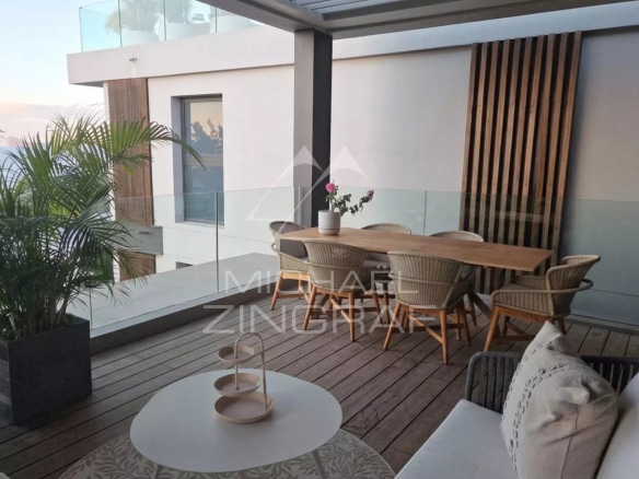 Terrasse d'un penthouse avec mobilier moderne et vue dégagée.