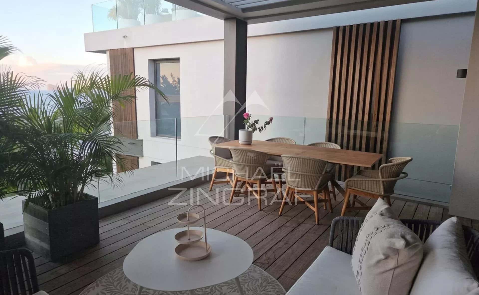 Terrasse d'un penthouse avec mobilier moderne et vue dégagée.