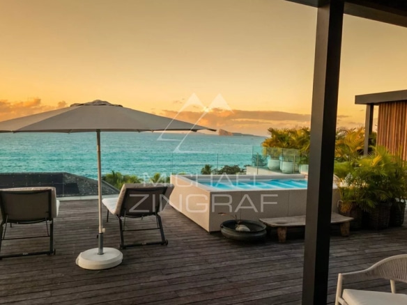 Terrasse d'un penthouse avec vue sur la mer, piscine et parasol à Pointe aux Canonniers.