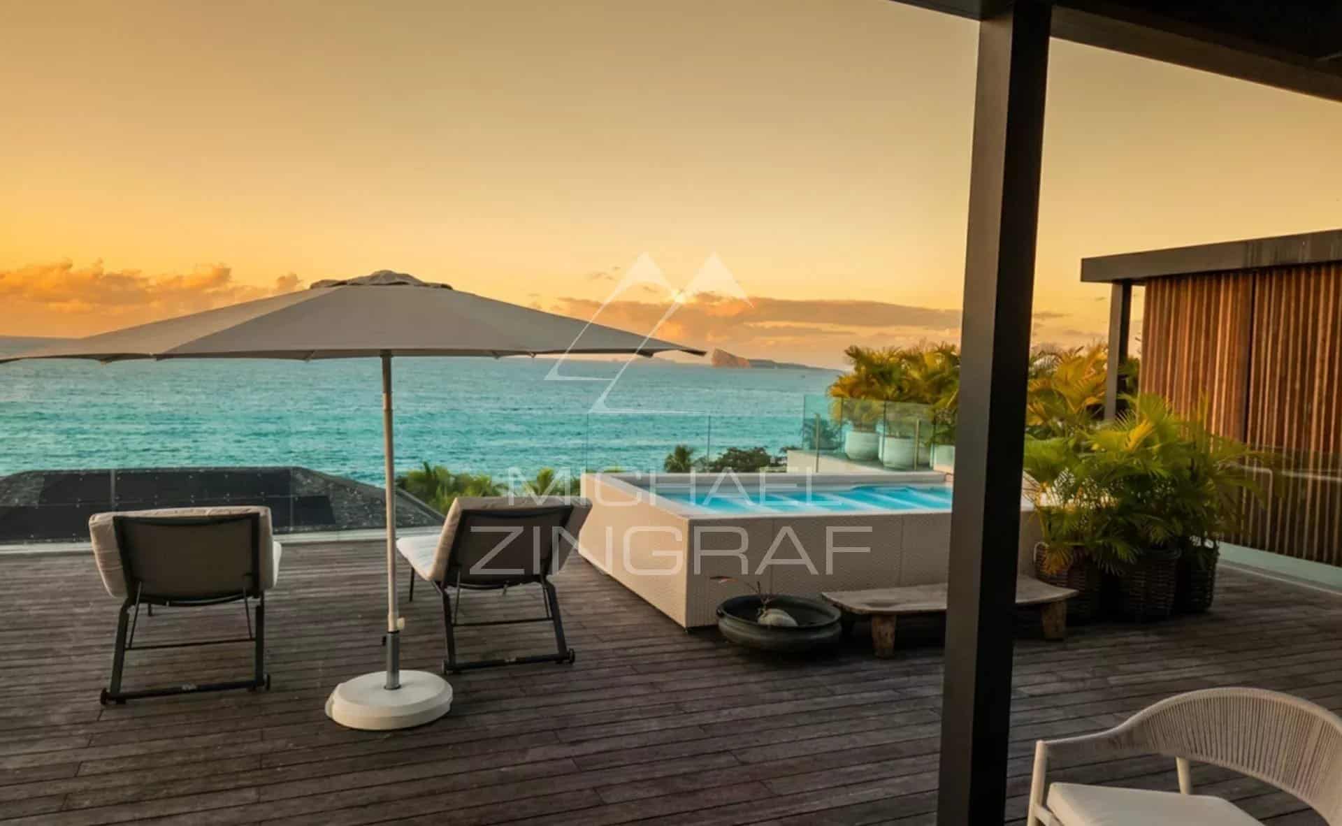 Terrasse d'un penthouse avec vue sur la mer, piscine et parasol à Pointe aux Canonniers.