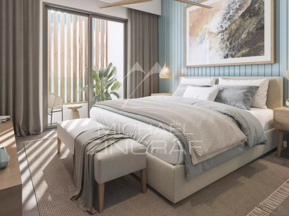 Chambre moderne d'un penthouse avec lit king-size et fenêtres donnant sur l'extérieur à Grand Baie.