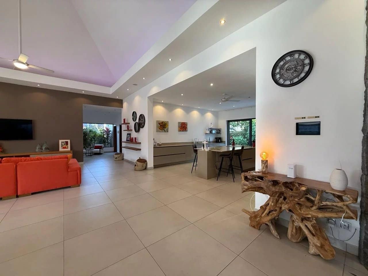 Intérieur d'une villa contemporaine à Pereybère avec salon et cuisine ouverte.