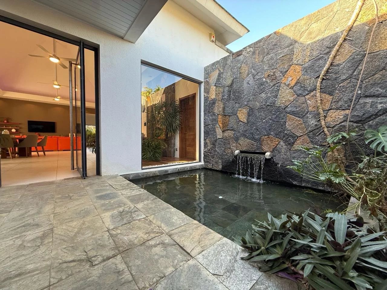 Vue d'une villa contemporaine avec piscine et aménagement paysager à Pereybère.