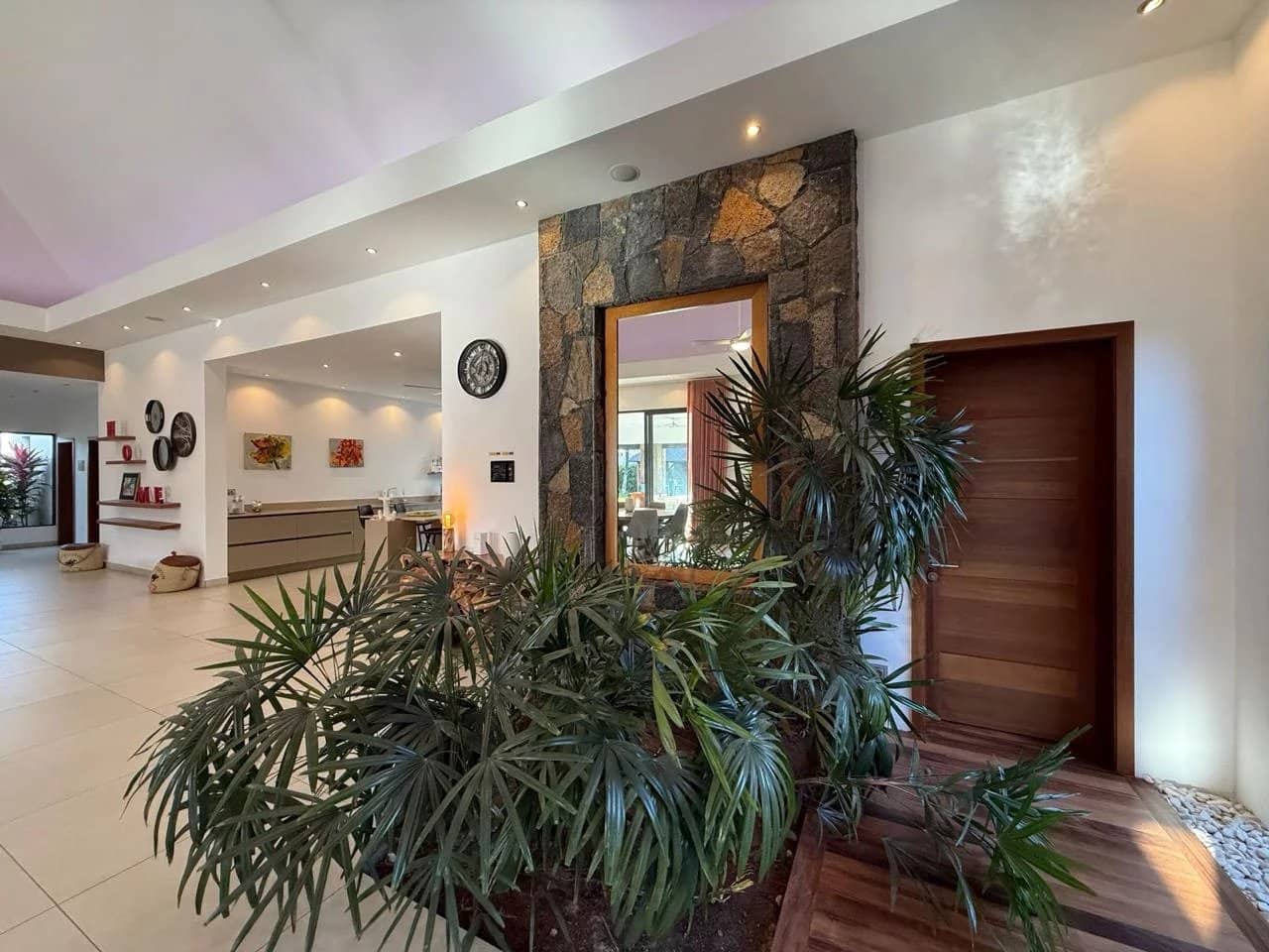 Intérieur d'une villa contemporaine avec des plantes et un miroir, située à Pereybère.