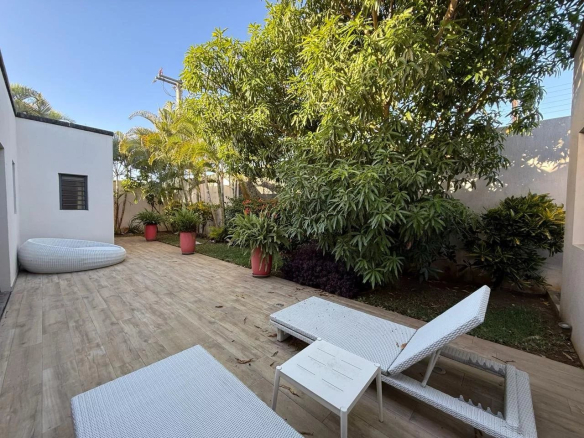 Jardin d'une villa contemporaine avec chaises longues et plantes à Pereybère.