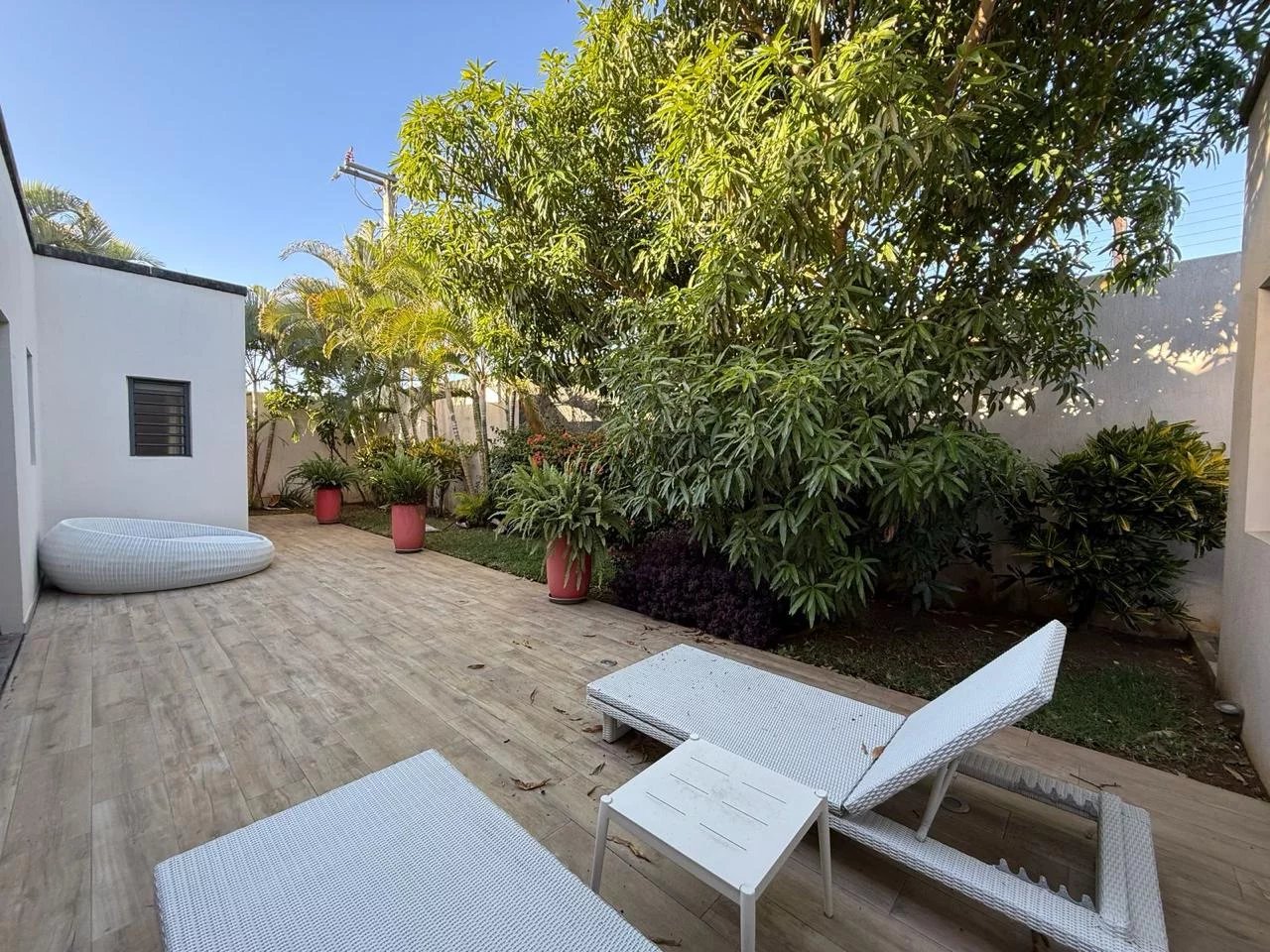 Jardin d'une villa contemporaine avec chaises longues et plantes à Pereybère.