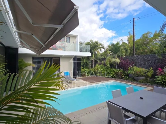 Contemporary villa with swimming pool and outdoor space in Pereybère, surrounded by greenery.