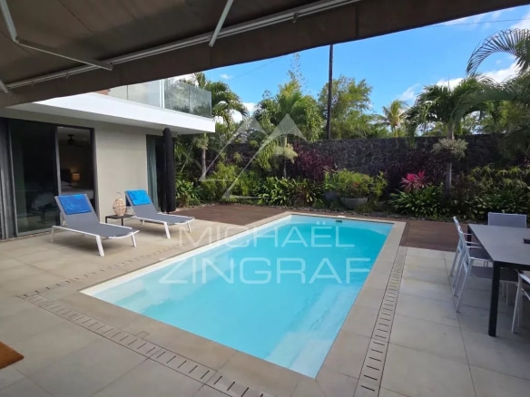 Contemporary villa with swimming pool and terrace in Pereybère, surrounded by vegetation.