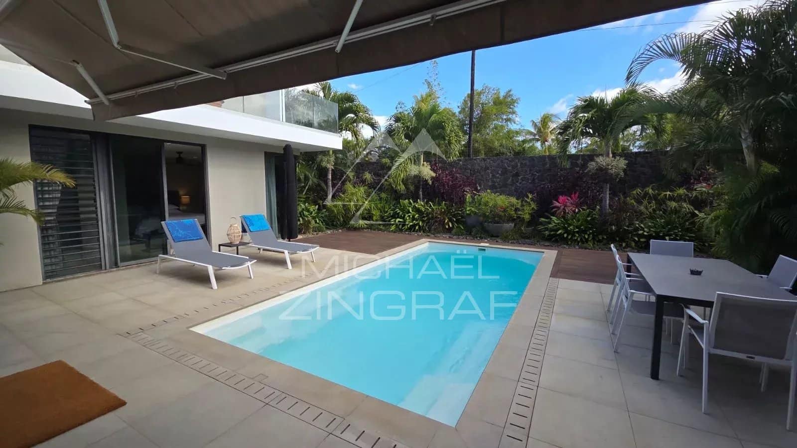 Contemporary villa with swimming pool and terrace in Pereybère, surrounded by vegetation.