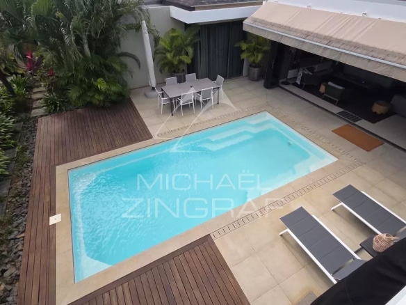 Aerial view of a contemporary villa with swimming pool and terrace in Pereybère.
