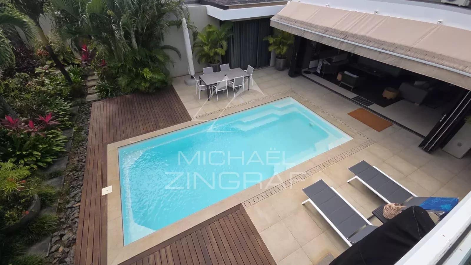 Aerial view of a contemporary villa with swimming pool and terrace in Pereybère.