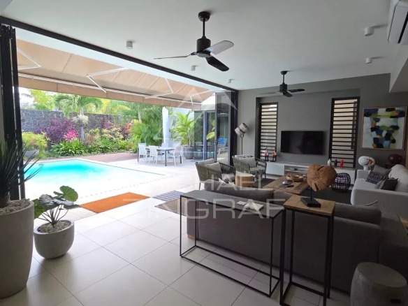 Interior of a contemporary villa in Pereybère with swimming pool and modern living room.