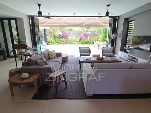 Interior of a contemporary villa in Pereybère, spacious living room with sofas and access to the outside.