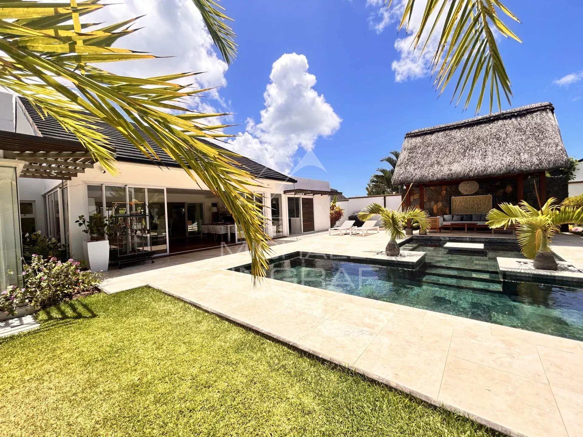 Modern villa with swimming pool and outdoor space in Grand Baie, surrounded by greenery.