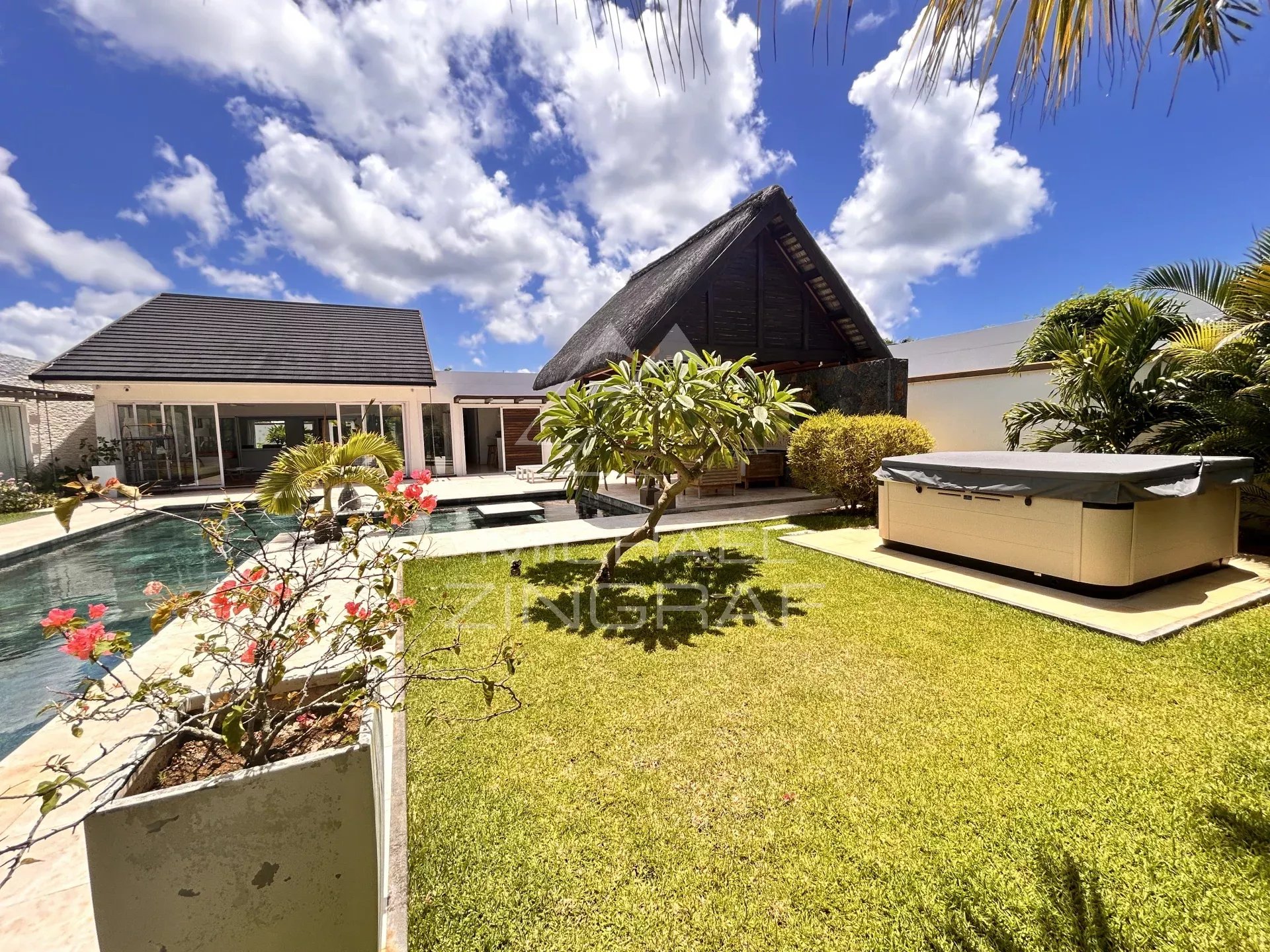 Villa with pool and garden in Grand Baie, surrounded by greenery and flowers.