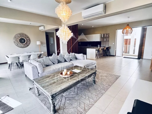 Intérieur d'un penthouse moderne à Grand Baie avec salon, cuisine ouverte et décoration élégante.