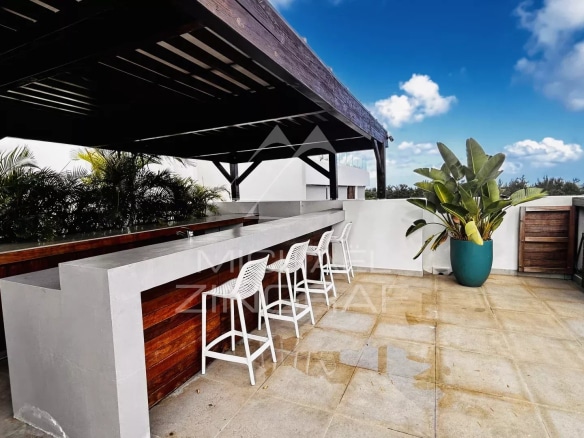 Terrasse d'un penthouse à Grand Baie avec bar et vue sur l'océan.