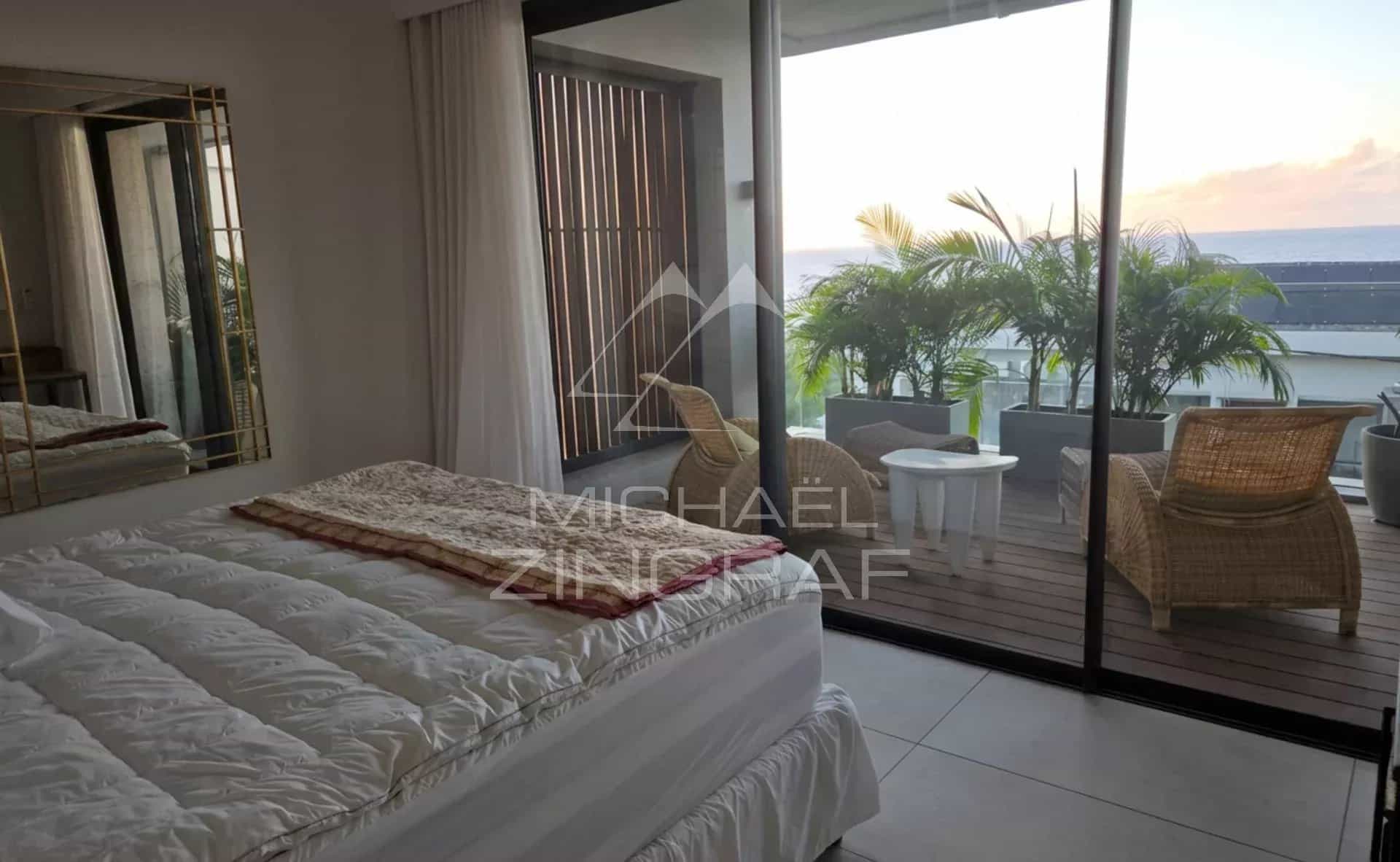 Penthouse with sea view in Pointe aux Canonniers Interior of a penthouse with bed and access to a balcony, sea view.